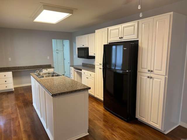 kitchen with black appliances, dark hardwood / wood-style floors, a center island with sink, and white cabinets