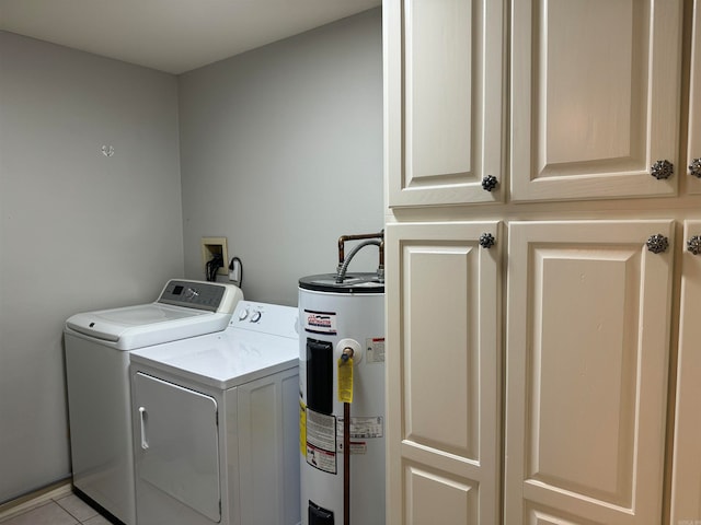 laundry room featuring electric water heater, light tile patterned floors, cabinets, and washing machine and dryer