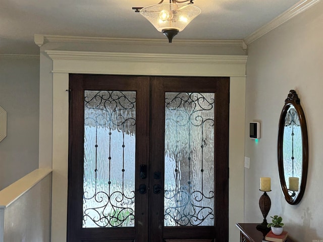 entryway with ornamental molding and french doors