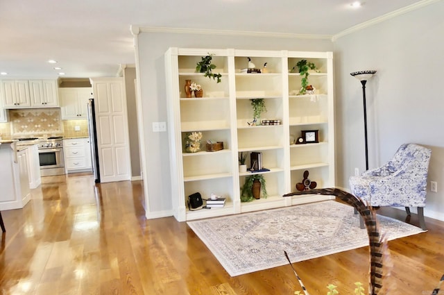 sitting room featuring ornamental molding and light hardwood / wood-style floors