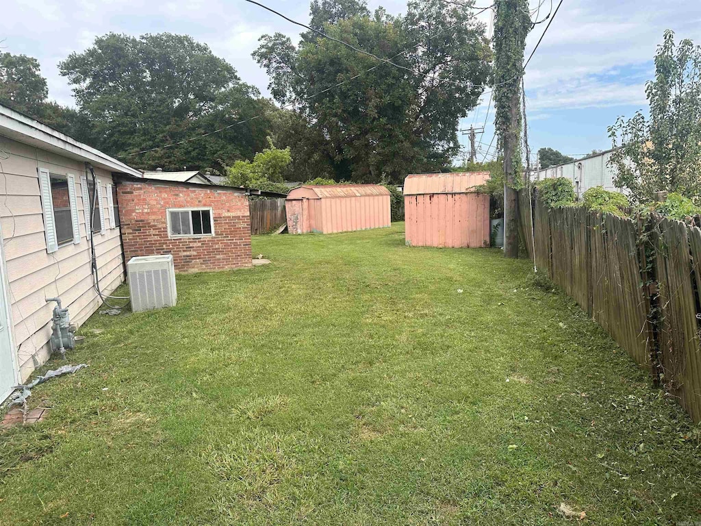 view of yard with a storage shed and central AC