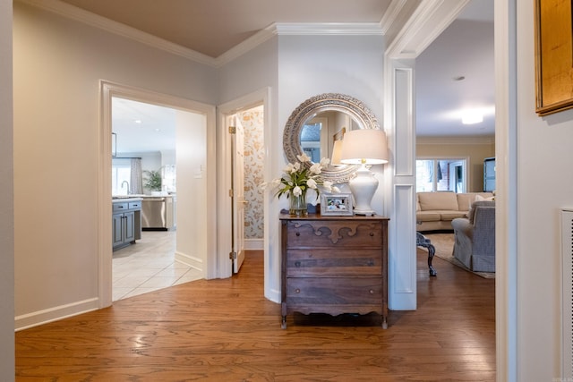 corridor featuring ornamental molding, light hardwood / wood-style flooring, and sink