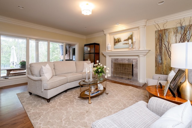 living room with ornamental molding, hardwood / wood-style floors, and a tile fireplace