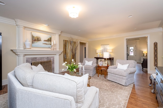 living room with ornamental molding, a high end fireplace, and light hardwood / wood-style flooring