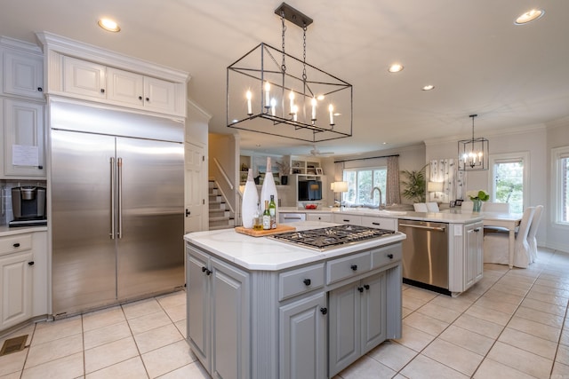 kitchen featuring a center island, stainless steel appliances, ornamental molding, and a healthy amount of sunlight