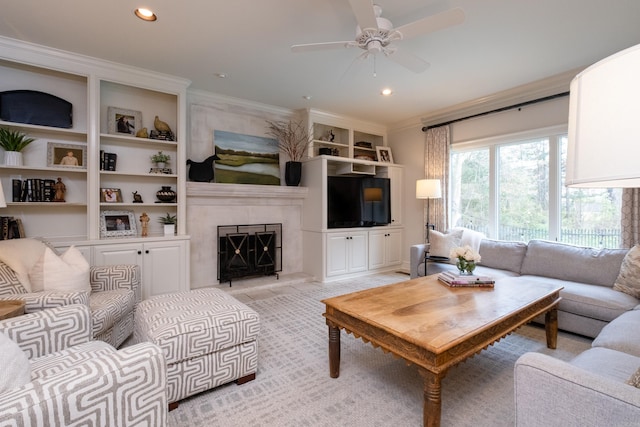 living room with built in shelves, ceiling fan, ornamental molding, and light carpet