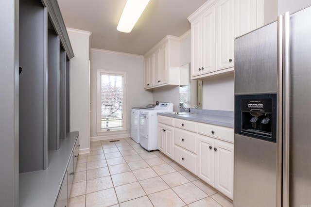 laundry area with ornamental molding, light tile patterned floors, cabinets, and washer and dryer