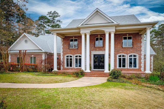 neoclassical home featuring a front yard