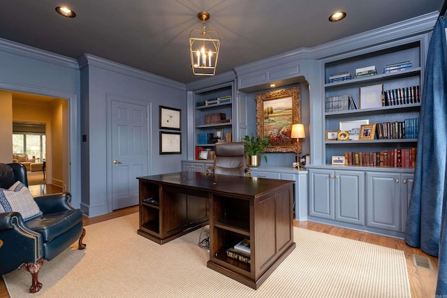 home office featuring crown molding, light hardwood / wood-style flooring, built in features, and a chandelier