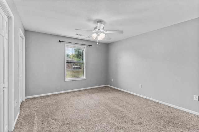 unfurnished bedroom with a textured ceiling, ceiling fan, and carpet