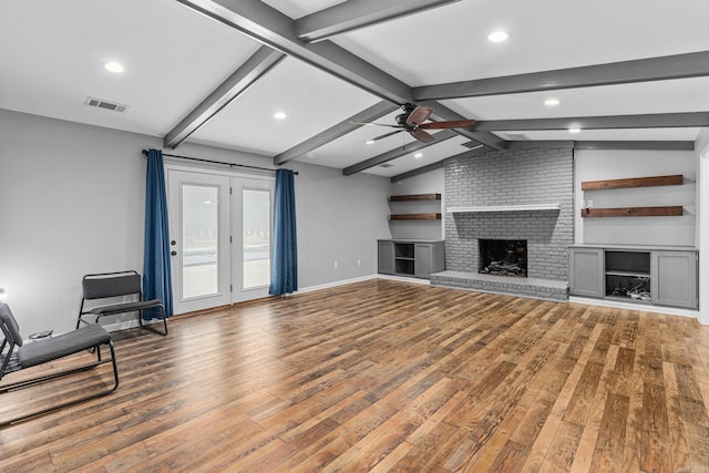 unfurnished living room with ceiling fan, hardwood / wood-style flooring, a fireplace, and lofted ceiling with beams