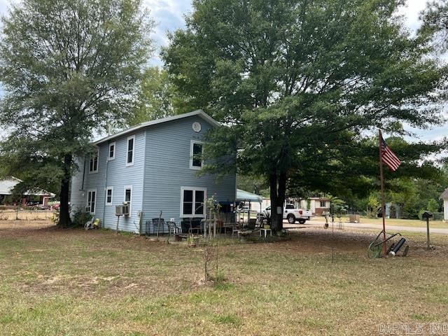 view of side of home with a lawn and cooling unit