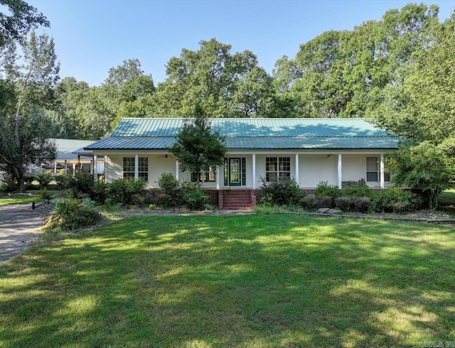 view of front of property with brick siding, covered porch, metal roof, and a front yard