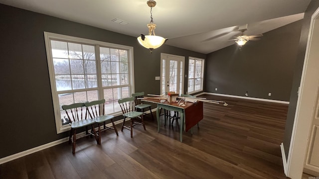dining space with a ceiling fan, wood finished floors, visible vents, baseboards, and vaulted ceiling