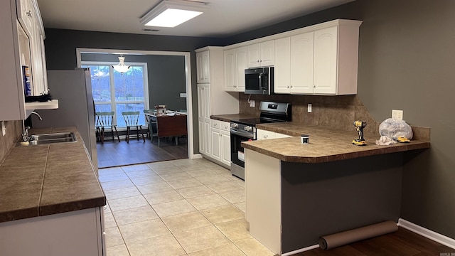 kitchen featuring visible vents, backsplash, appliances with stainless steel finishes, a peninsula, and white cabinets