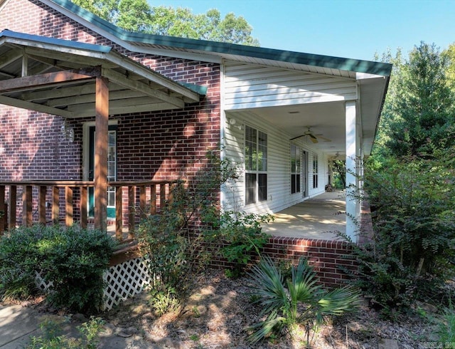 exterior space with brick siding, a ceiling fan, and a patio area