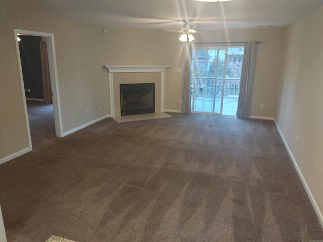 unfurnished living room featuring dark colored carpet and ceiling fan