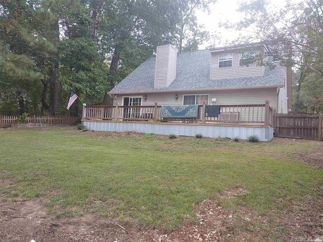 back of property featuring a wooden deck and a yard