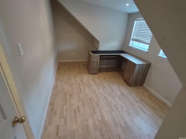 additional living space with light hardwood / wood-style flooring and built in desk