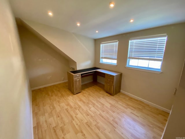 unfurnished office featuring light hardwood / wood-style floors and built in desk