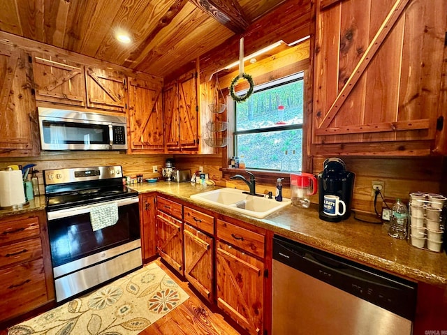 kitchen featuring sink, light hardwood / wood-style flooring, wooden walls, appliances with stainless steel finishes, and wooden ceiling