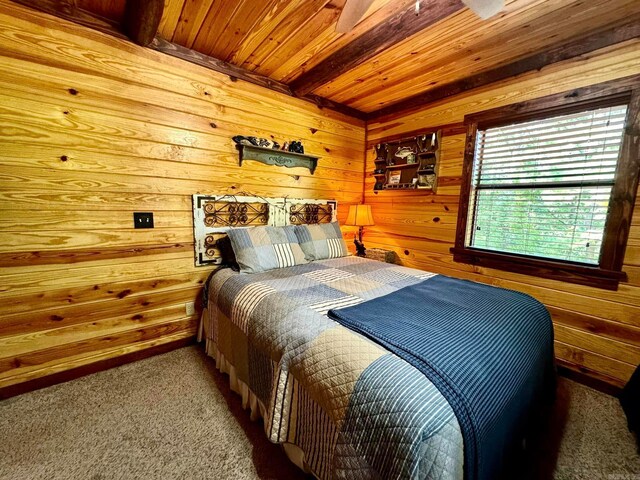 bedroom featuring wooden ceiling, beam ceiling, carpet flooring, and wooden walls