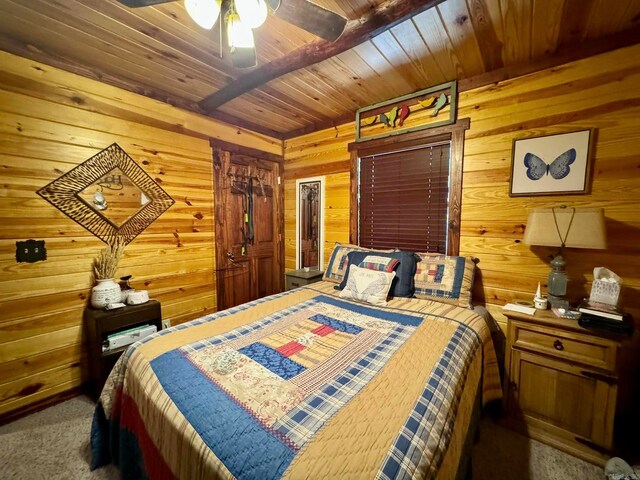 bedroom with wood walls, wood ceiling, dark carpet, and ceiling fan