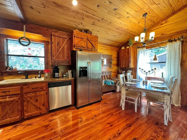 kitchen with wood-type flooring, a notable chandelier, stainless steel appliances, and sink