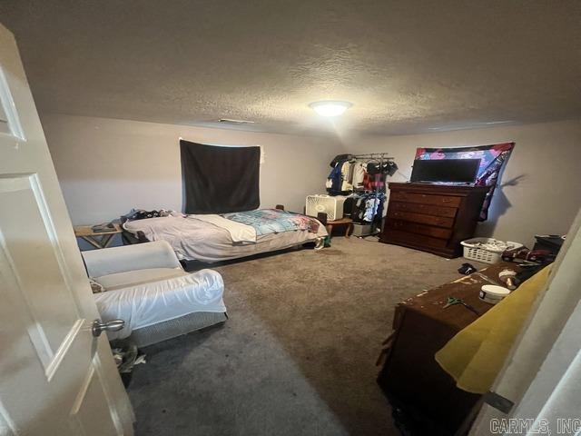 bedroom with a textured ceiling and carpet