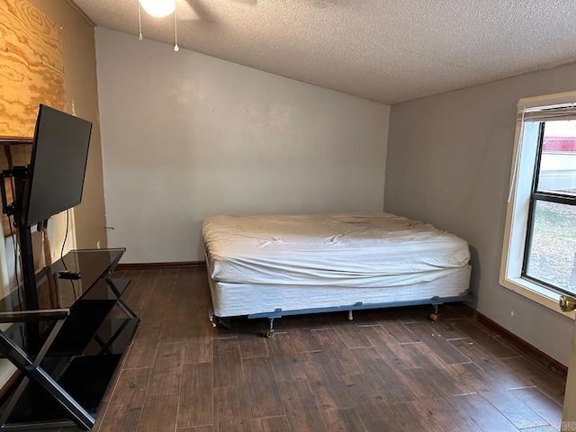 bedroom featuring dark wood-type flooring, a textured ceiling, and ceiling fan