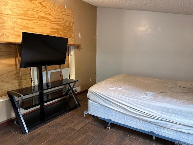 bedroom with dark hardwood / wood-style flooring and a textured ceiling