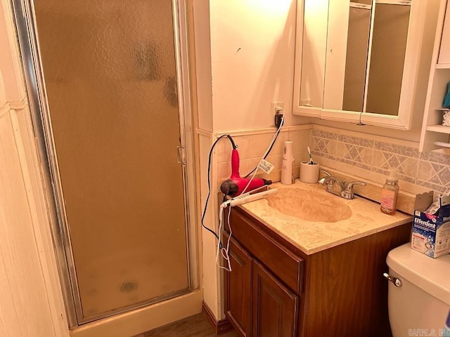 bathroom with toilet, backsplash, an enclosed shower, and vanity