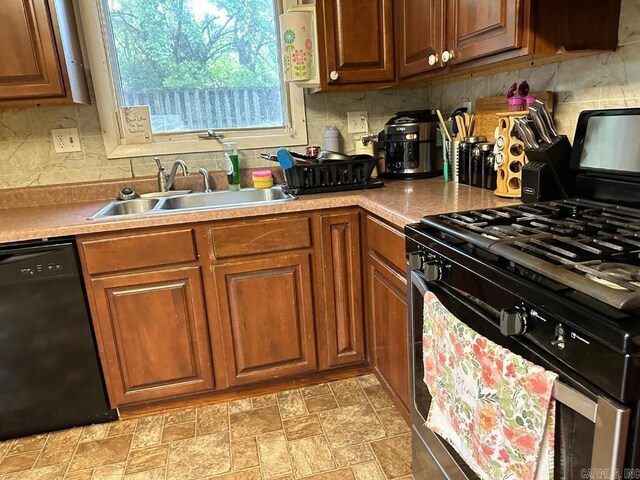 kitchen featuring backsplash, vaulted ceiling, sink, and appliances with stainless steel finishes