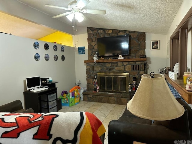 living room with a textured ceiling, vaulted ceiling, light tile patterned floors, a stone fireplace, and ceiling fan