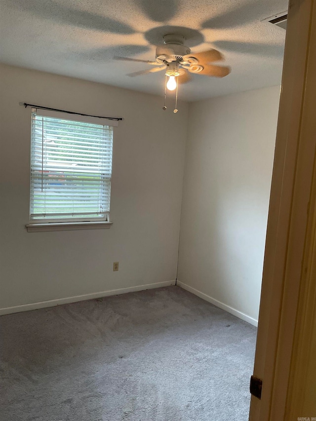 carpeted empty room with a textured ceiling and ceiling fan