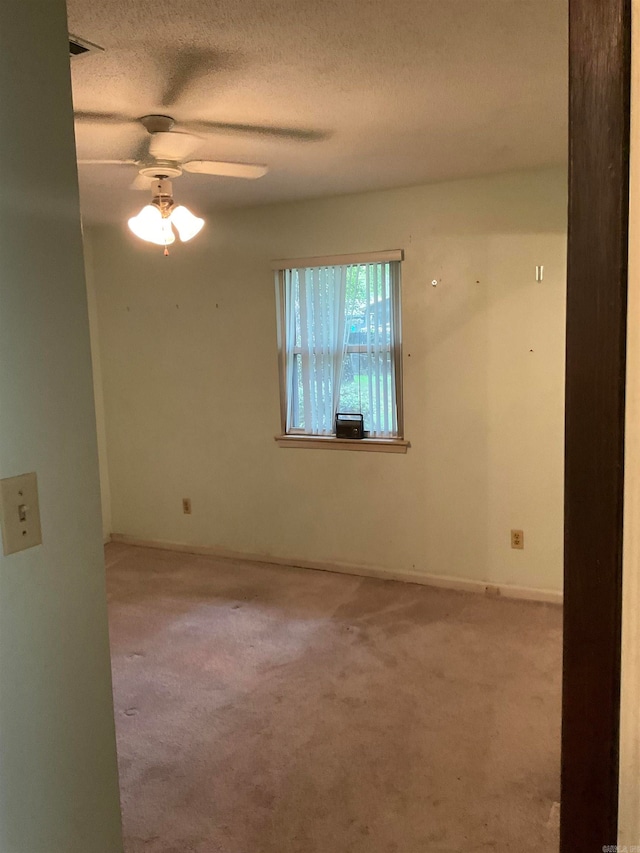 carpeted spare room with a textured ceiling and ceiling fan