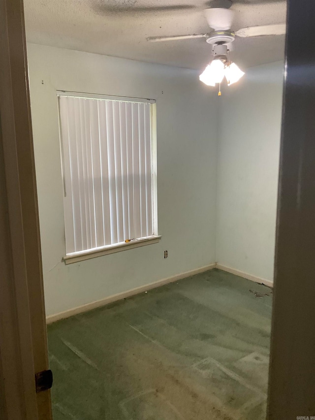 empty room featuring ceiling fan, carpet, and a textured ceiling