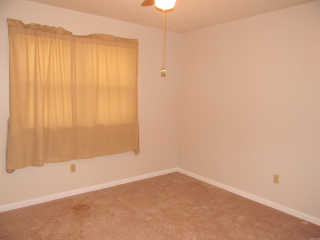 carpeted spare room with ceiling fan and a textured ceiling