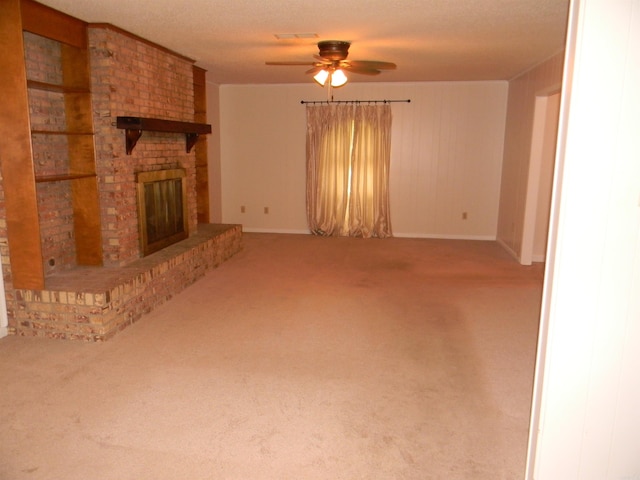 unfurnished living room featuring a brick fireplace, ceiling fan, and carpet floors