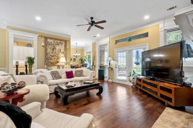 living room featuring a wealth of natural light, ornamental molding, dark hardwood / wood-style floors, and ceiling fan with notable chandelier