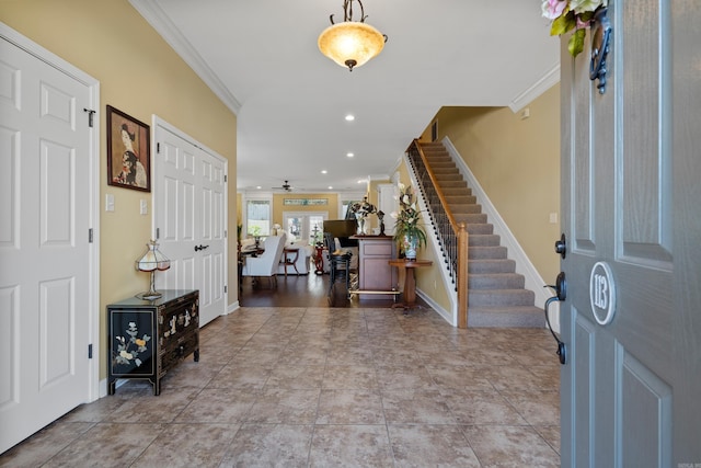 entryway with ceiling fan, crown molding, and light hardwood / wood-style flooring