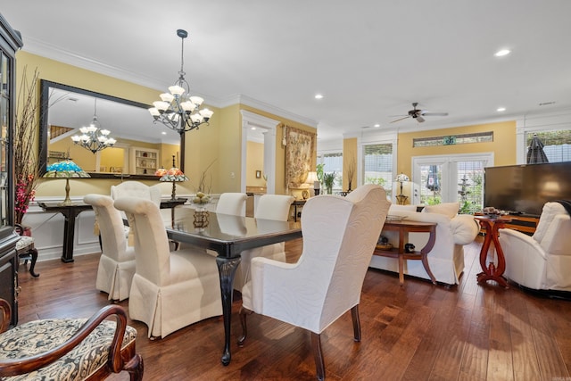 dining area featuring dark wood-type flooring, ornamental molding, ceiling fan with notable chandelier, and french doors