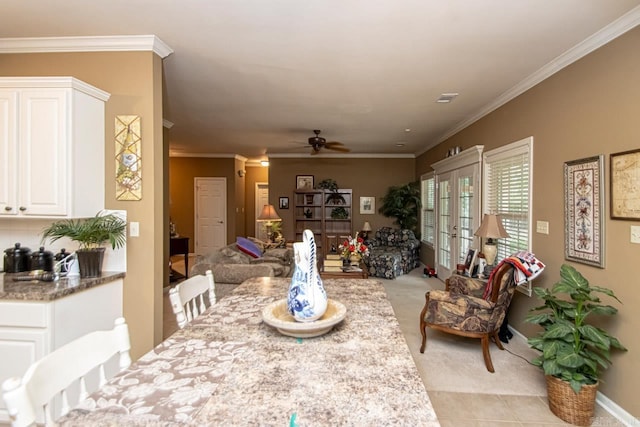 tiled dining room featuring ceiling fan, french doors, and crown molding