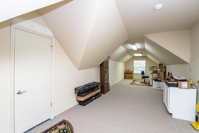 bonus room with lofted ceiling and light carpet