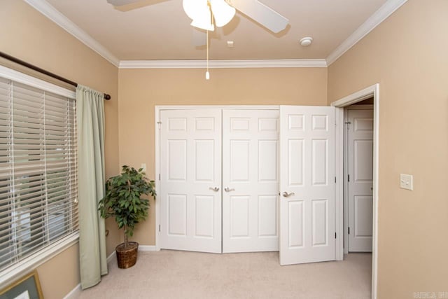 carpeted bedroom with ceiling fan, a closet, and crown molding