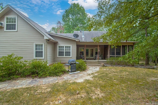 rear view of property featuring a lawn