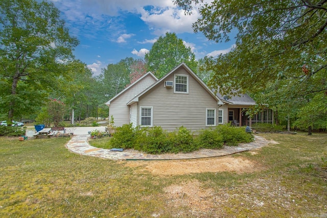 view of side of property with a sunroom and a yard