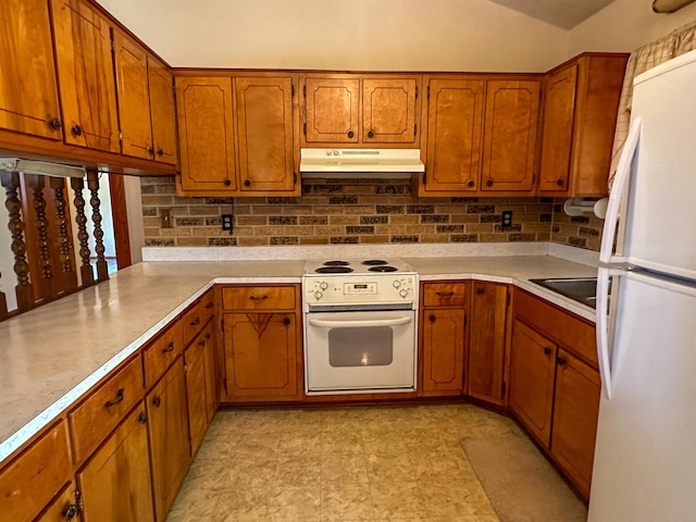 kitchen featuring white appliances, sink, and kitchen peninsula