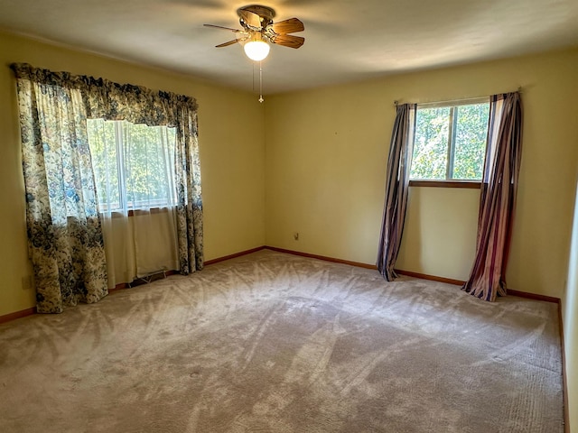 carpeted spare room featuring ceiling fan