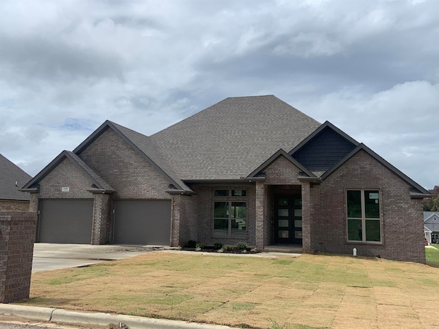 view of front of property with a garage and a front lawn